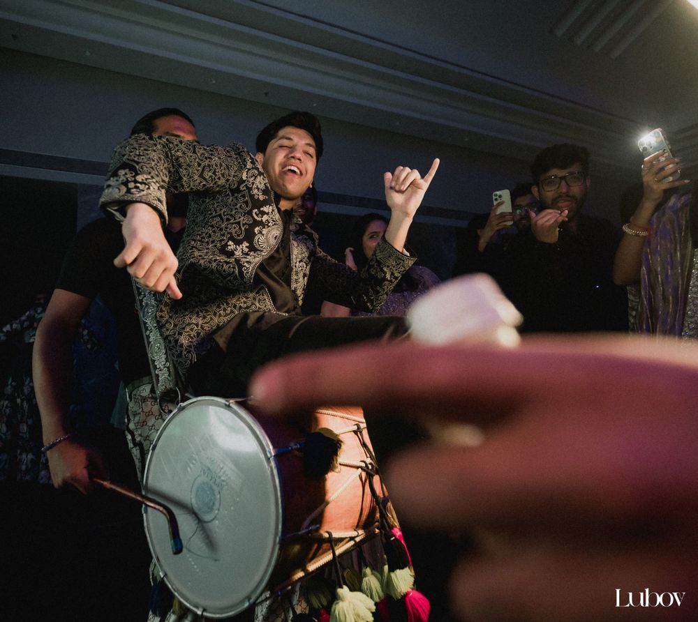 Party guests dance and play drums during a lively wedding celebration.
