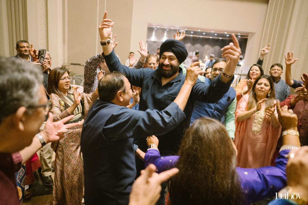 Celebratory crowd with raised hands during an energetic indoor celebration.