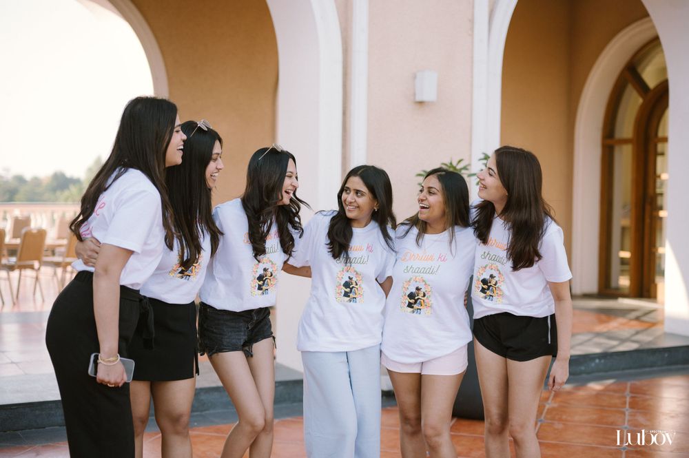 Friends in coordinated outfits gather and smile under outdoor archways.