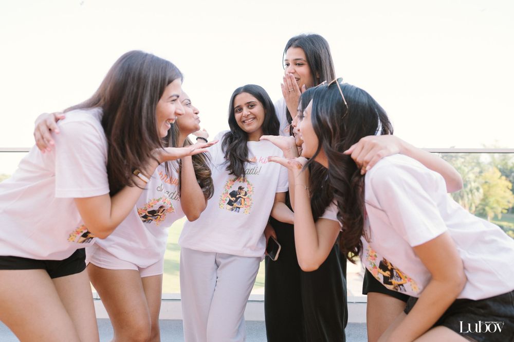 Group wearing matching t-shirts shares a lighthearted moment outdoors.