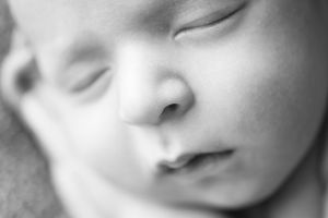 Detailed black-and-white close-up of a newborn baby's serene face, photographed by Phoebe Lee Photo in Toronto