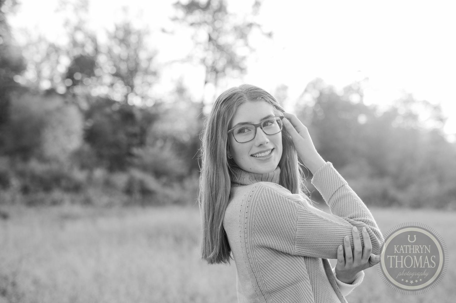 Black and white outdoor portrait with soft natural lighting and gentle expression.