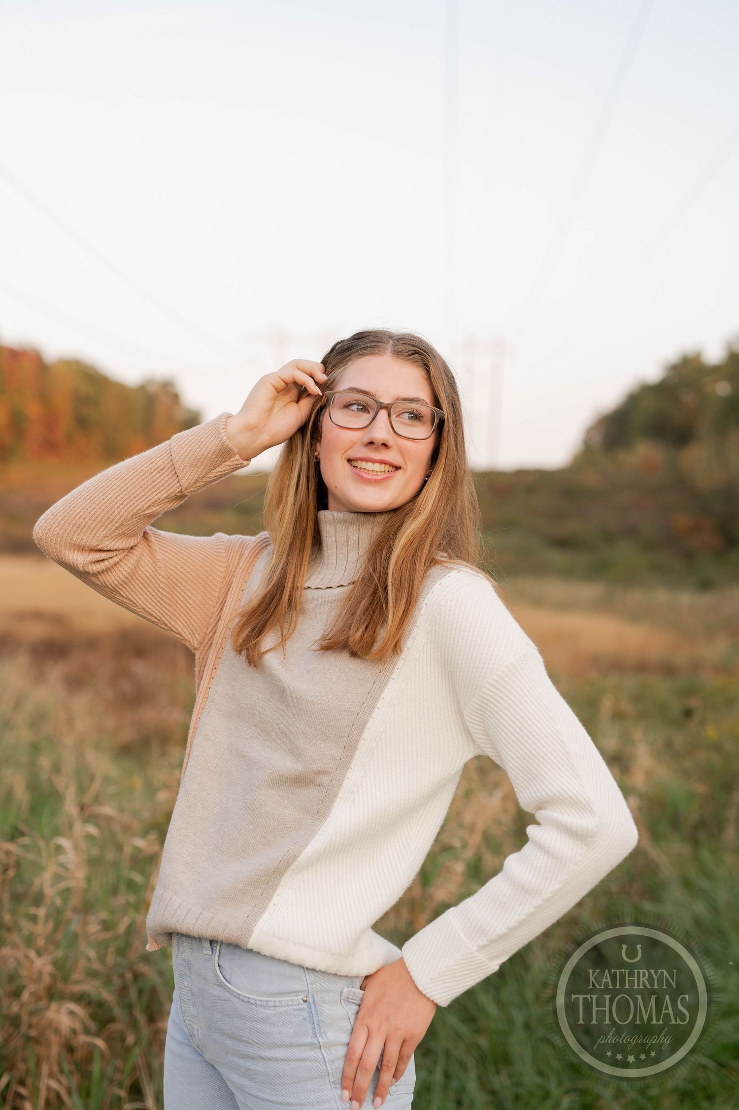 Candid portrait in two-tone sweater against golden sunset field background.