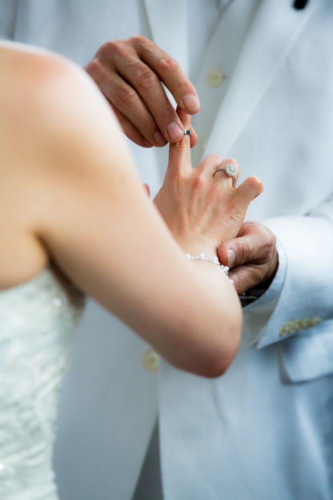 Close-up shot of wedding ring exchange between bride and groom.