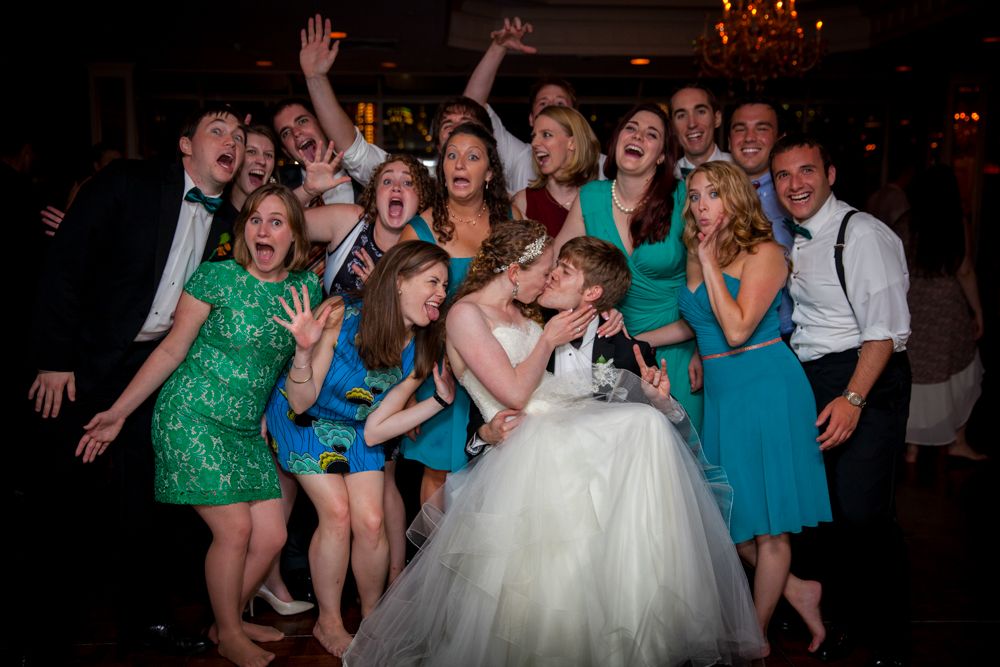 Wedding party making silly faces and fun poses for a group photo during the reception celebration.