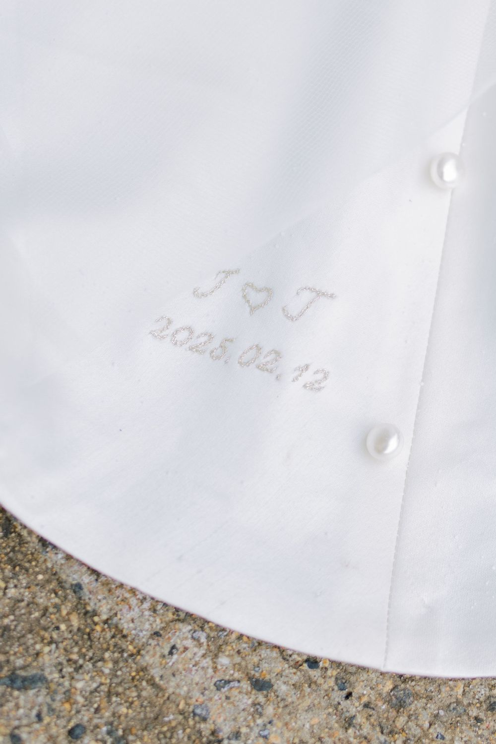 Close-up of embroidered wedding date on white fabric.