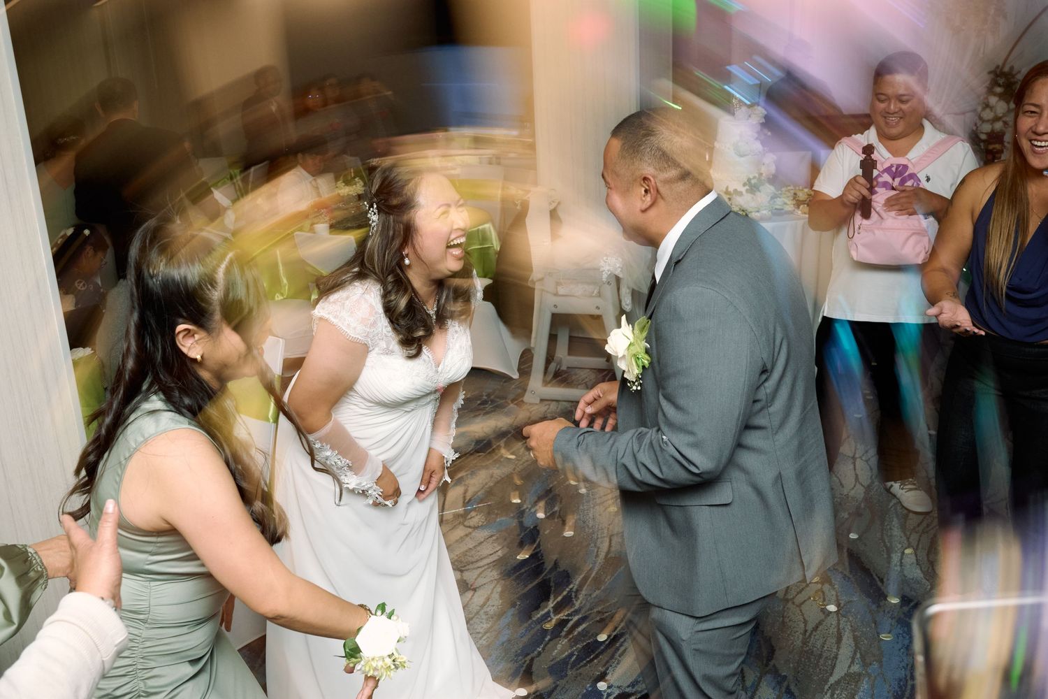 Wedding guests dance and celebrate with motion blur effects on the dance floor at a joyful reception party.