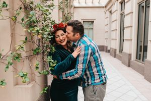 Romantic moment captured against urban building wall with climbing vines.