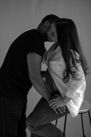 A romantic black and white portrait of a couple sharing an intimate moment.