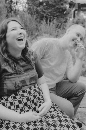 Black and white photo capturing genuine laughter during a maternity shoot.