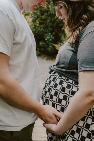Close-up maternity photo showing tender moment between couple outdoors.