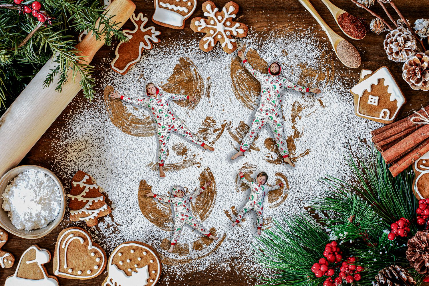 Holiday baking scene with gingerbread cookies, spices, and festive decorations on wooden surface.