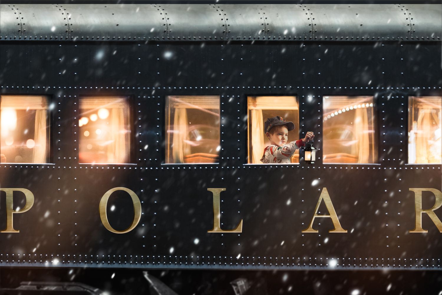 A snowy night view of an illuminated vintage Polar Express train car with glowing windows.