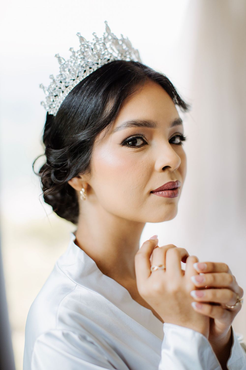 A wedding day portrait featuring a sparkling crystal tiara and elegant classic makeup.