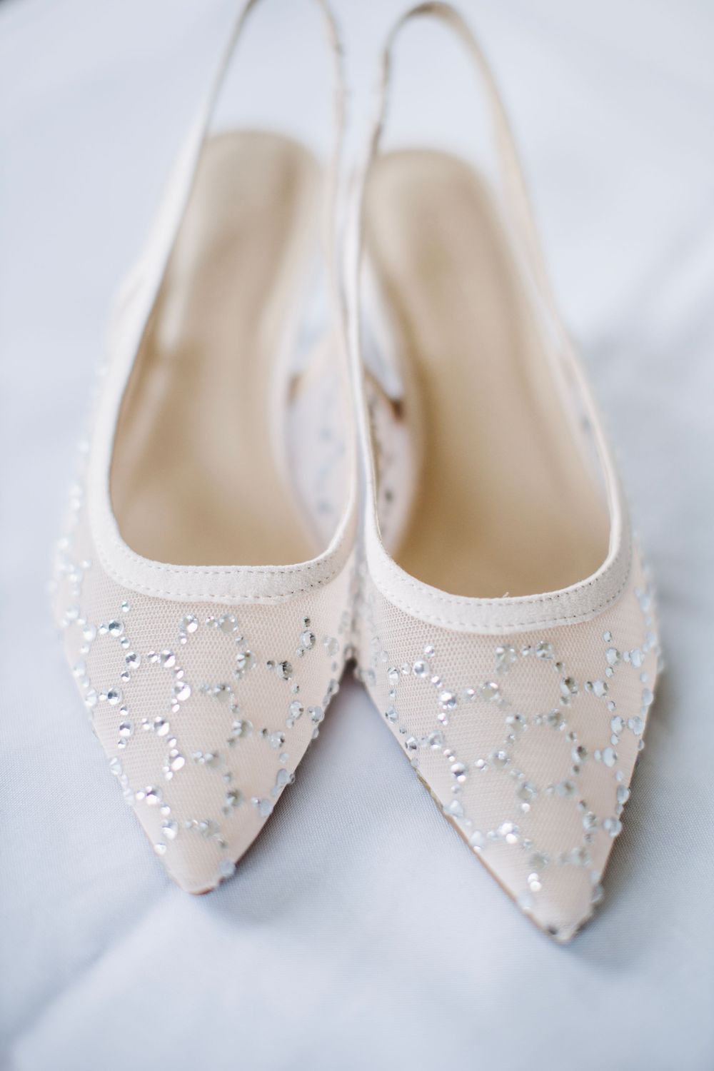 Elegant white bridal shoes with beaded details on pointed toe flats.