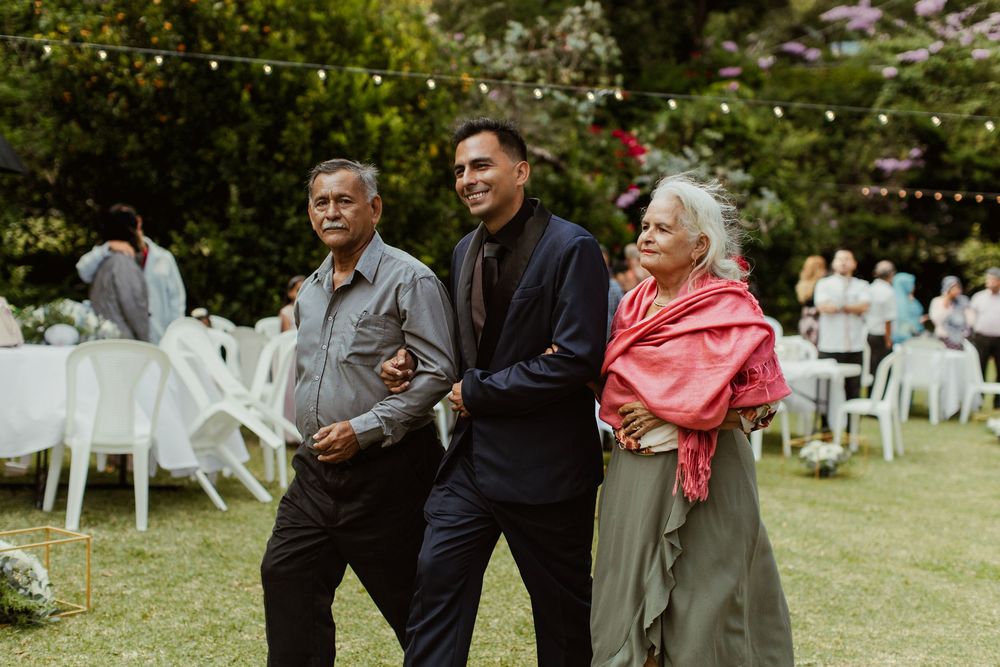 Wedding guests enjoying an outdoor garden reception with string lights.