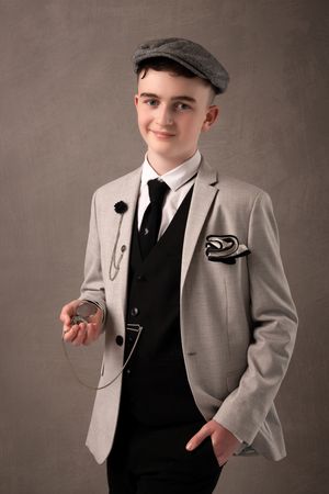 A series of five vintage-inspired portraits showing a person in a gray suit jacket, black vest, and flat cap against a dark background.