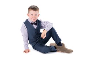 A child in formal attire sits on the floor in three different casual poses.