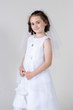 A young child in a flowing white dress poses gracefully in a series of studio portraits against a light background.