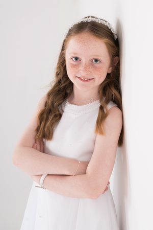 Young person in white sleeveless dress poses against white background in four different expressions.