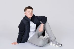 Professional studio portraits of a person in a navy blazer and light gray pants posing against a white backdrop.
