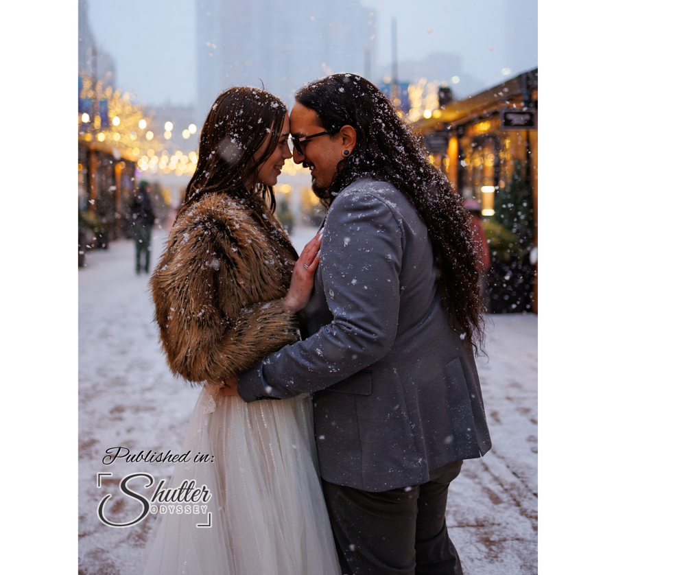 A romantic couple embracing in winter snow, with the bride wearing a white dress and fur coat during their special day.