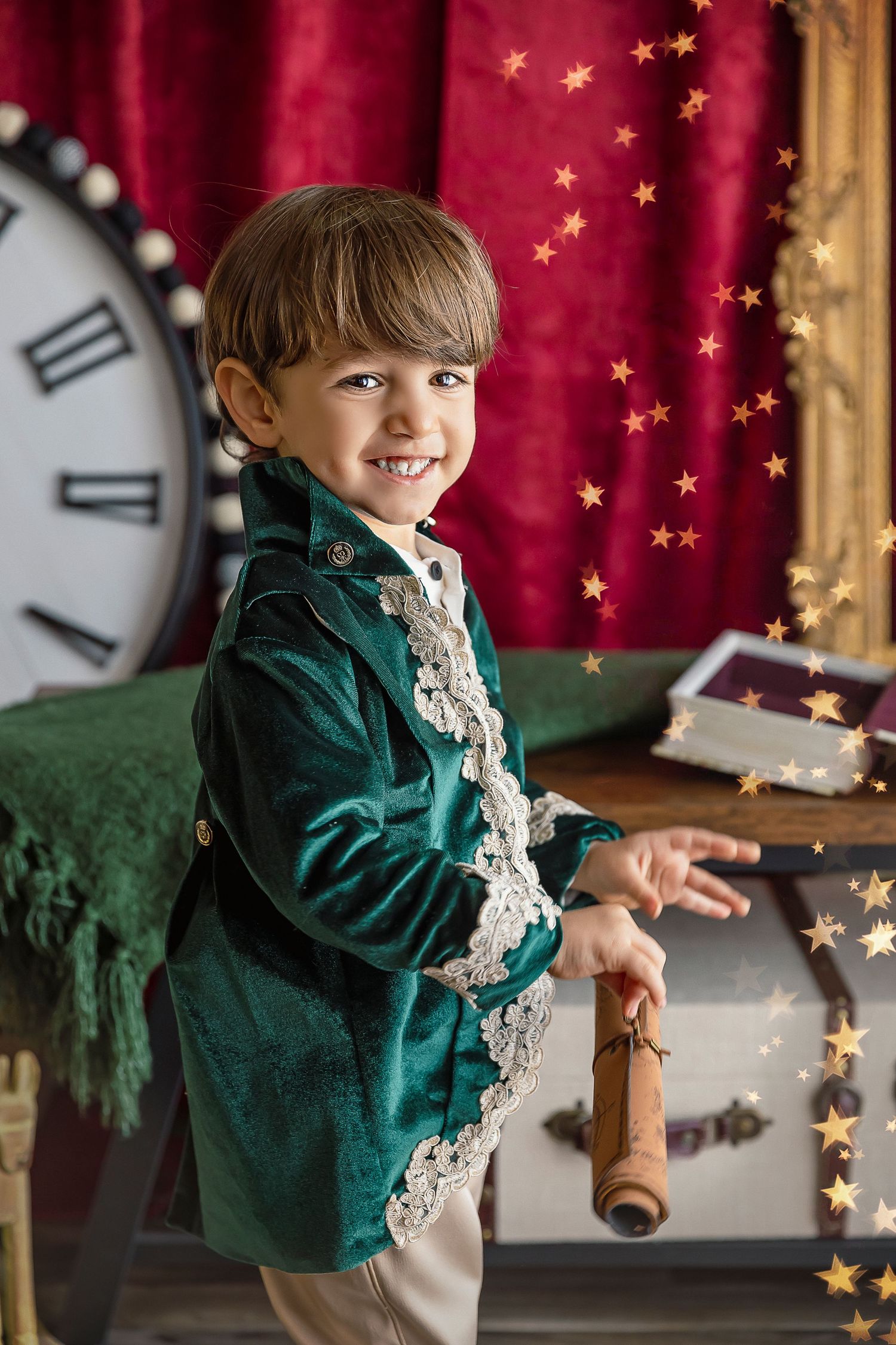 little boy smiles at the camera while being photographed by Detres in studio
