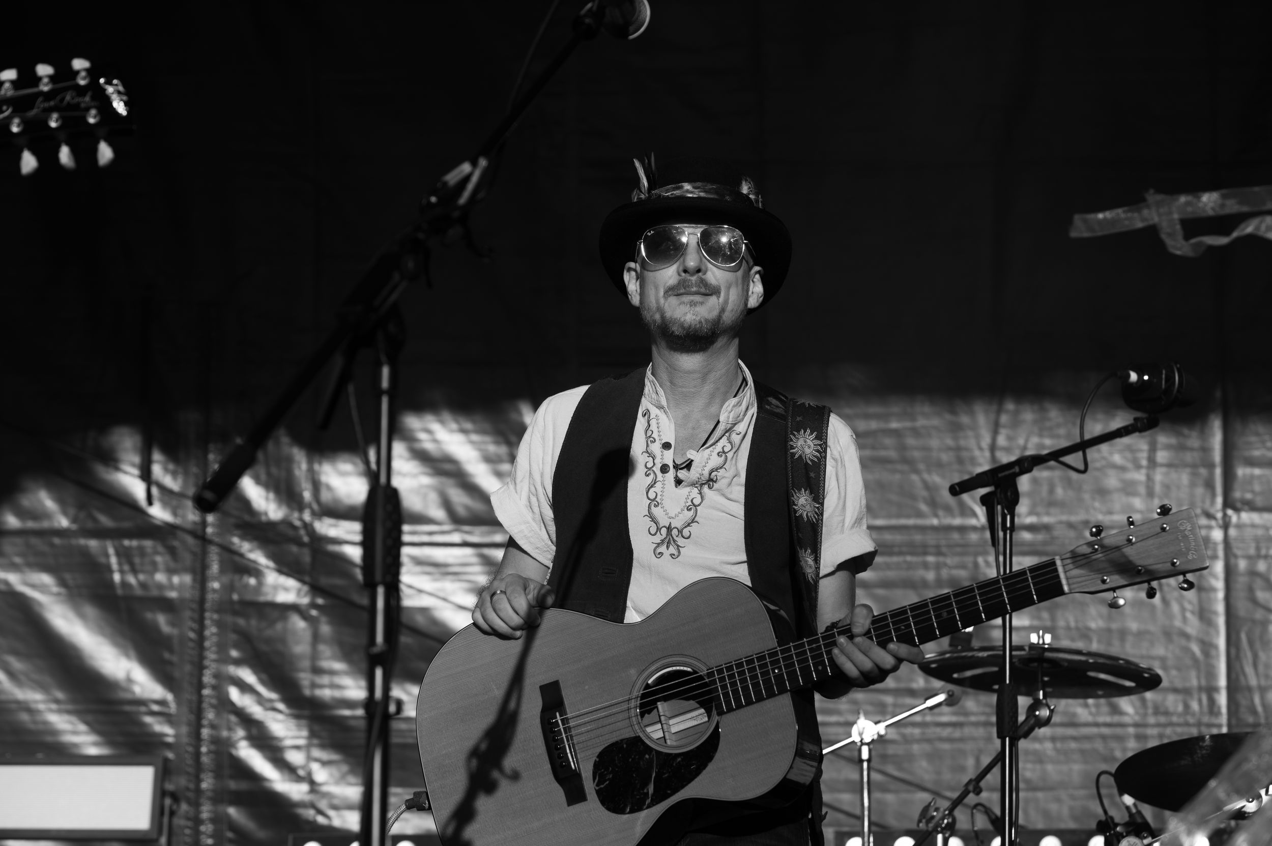 Black and white collage of musicians performing with guitars on stage during a live concert.