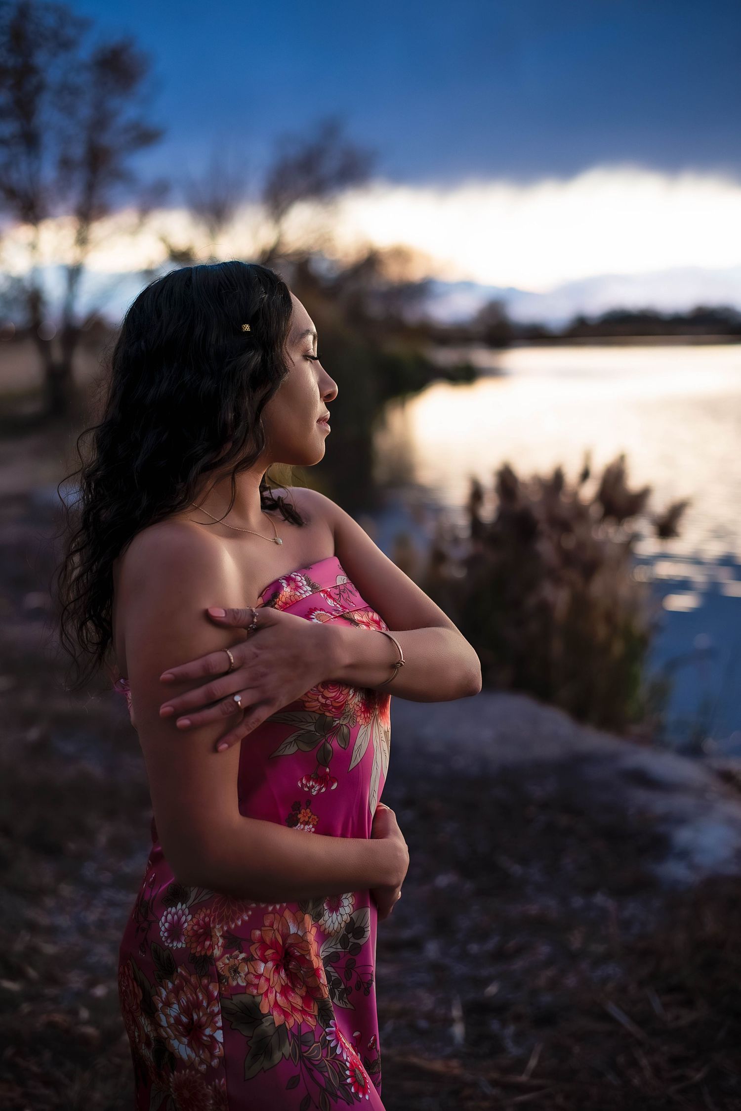 portrait of a woman embracing herself while watching a gorgeous sunset at the pond in Bountiful