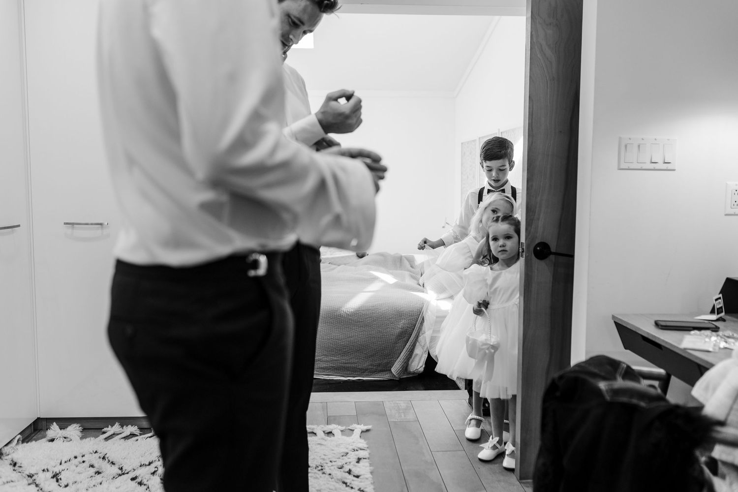Black and white photo strip showing candid moments and interactions between people in an indoor setting.