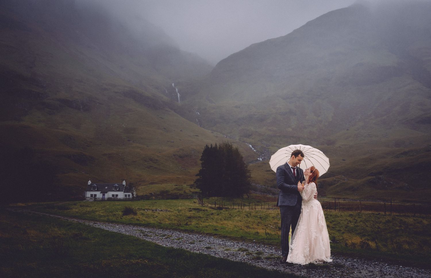 A misty mountain wedding ceremony unfolds in the Scottish Highlands with dramatic peaks and valleys in the background.