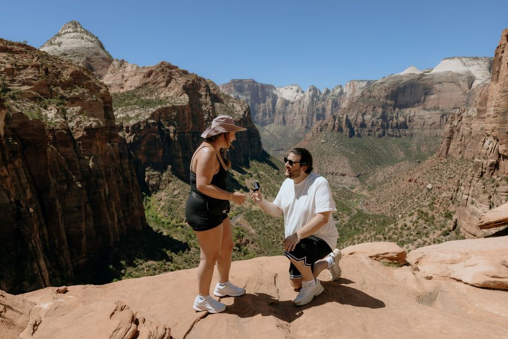Hikers exploring scenic viewpoints along canyon trails at Zion National Park in Utah during a sunny day.