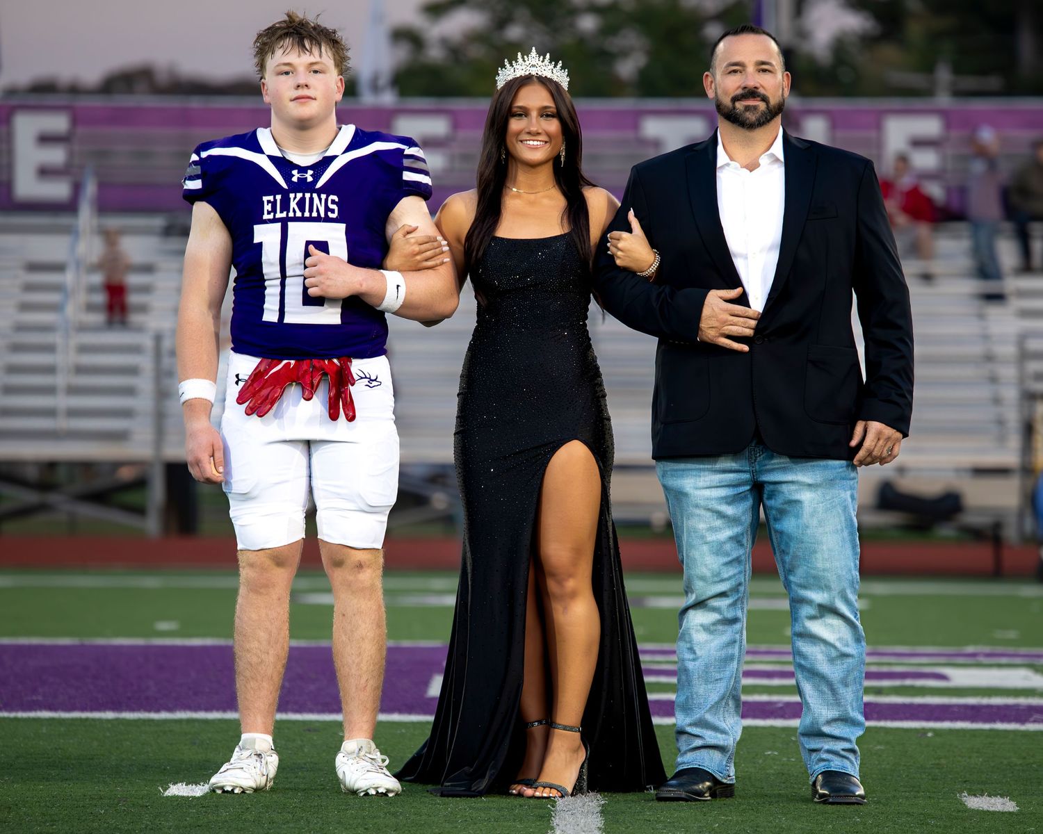 Football players and pageant contestants pose together on a football field during their Homecoming event in Elkins Arkansas photography