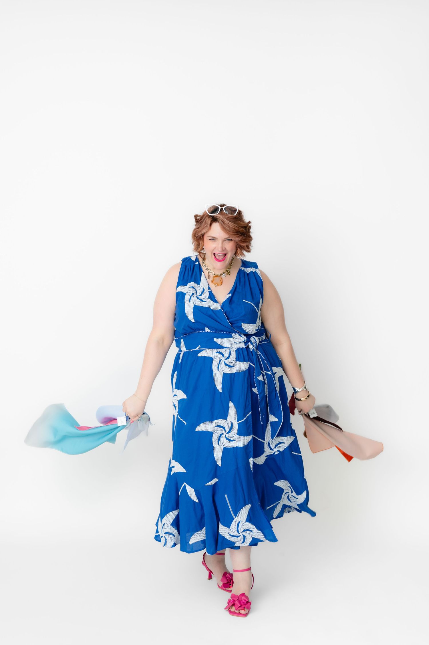 A person in a blue and white patterned dress strikes playful poses against a white background.
