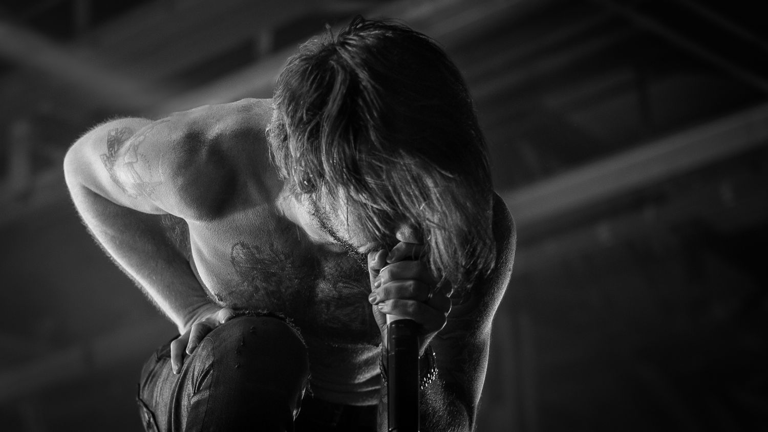 A silhouetted figure performs a graceful ballet dance pose against a dark background.