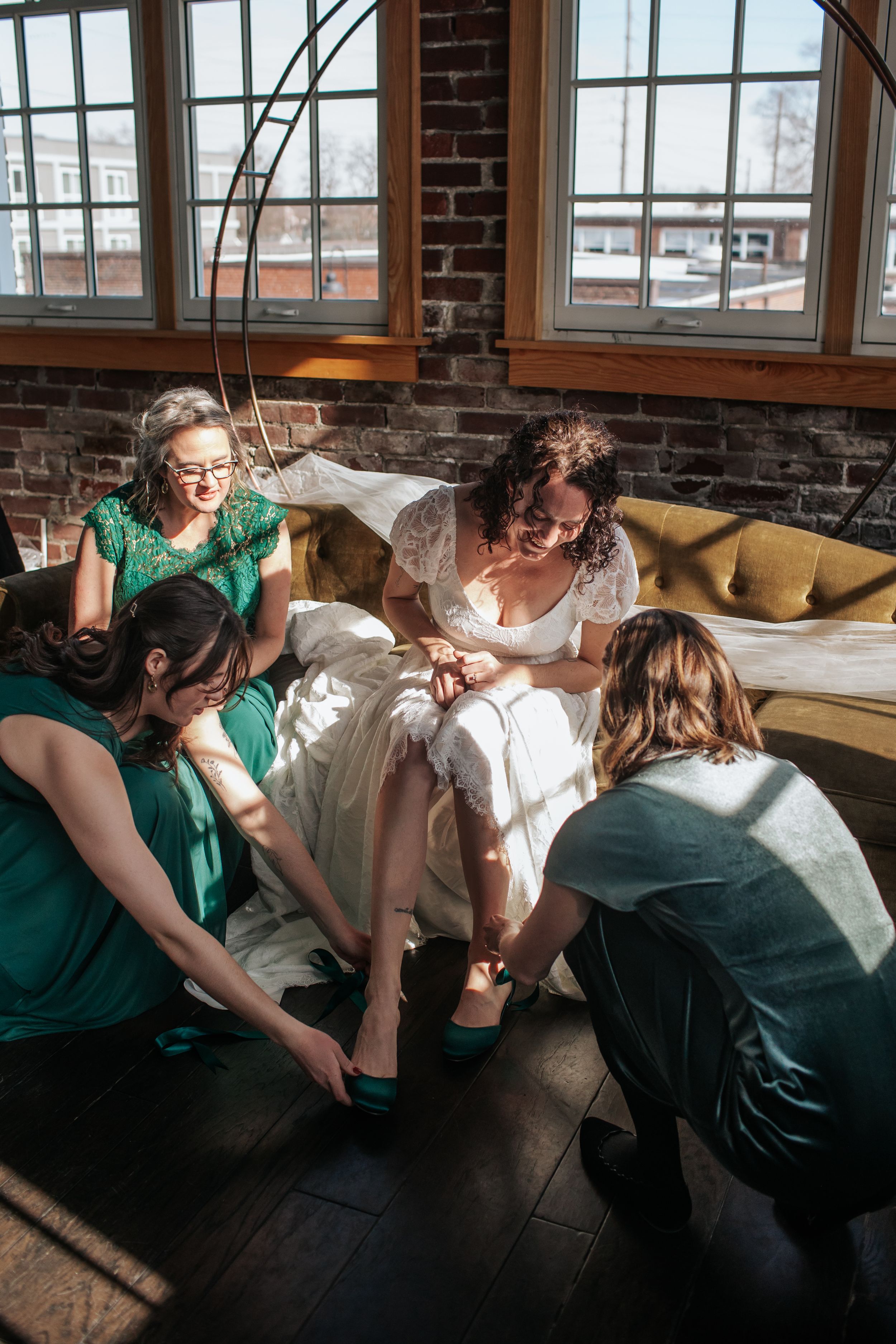 A sequence of five photos showing two people in green and white dresses leaning over and laughing together.