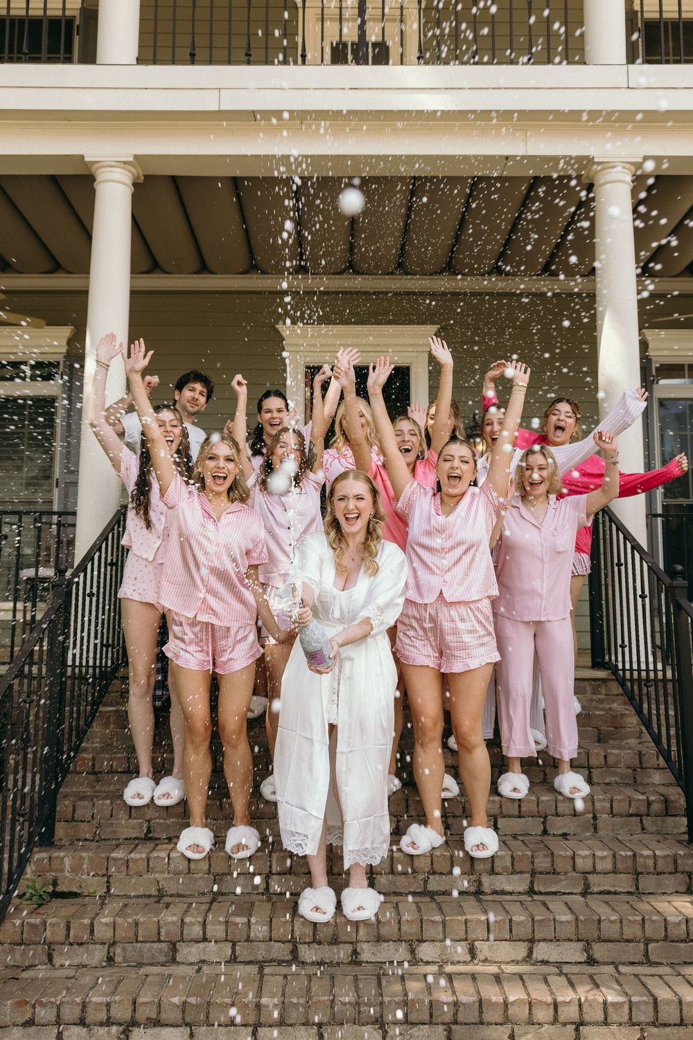 Bride and bridesmaids pop champagne while getting ready at Summerour Studio in Atlanta, Georgia