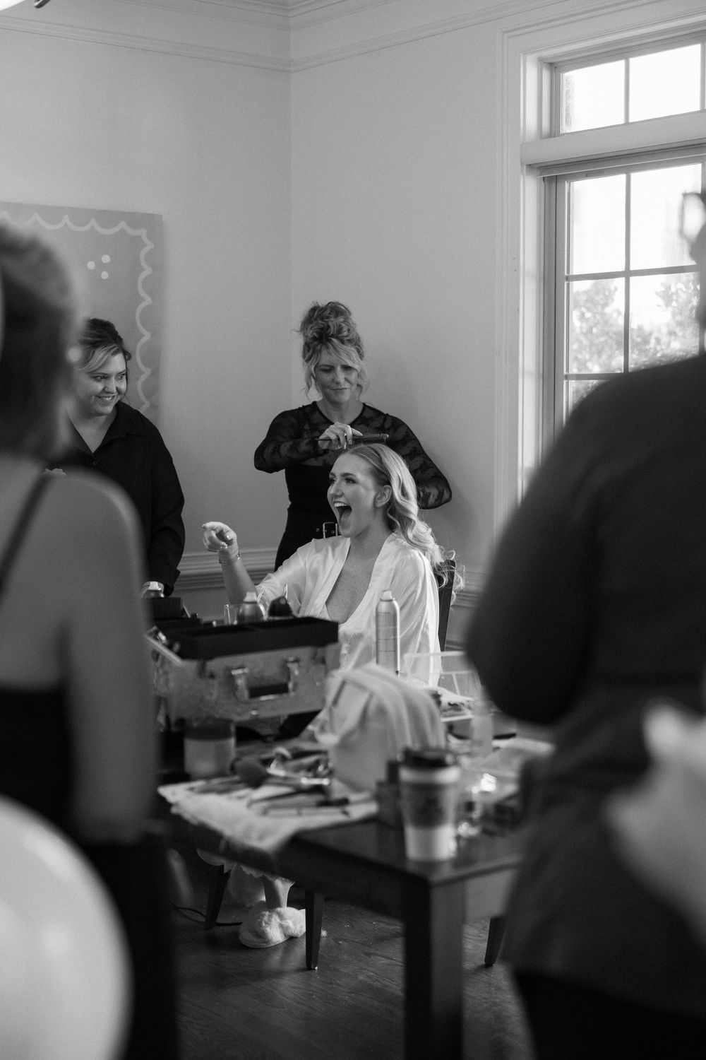 Black and white photo of bride getting hair and makeup done before Atlanta wedding