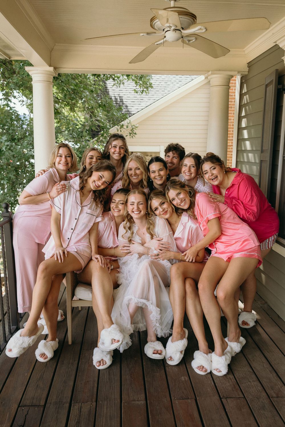 Group wearing matching pink robes and slippers posing together on a wooden porch at Summerour Studio in Atlanta, Georgia