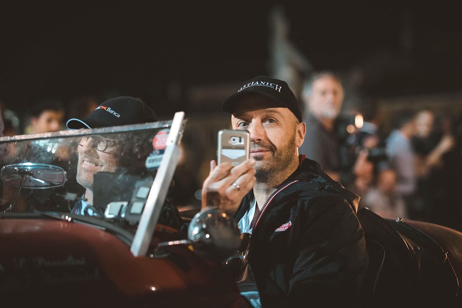 Auto sportiva d'epoca che attraversa una strada affollata durante l'evento Mille Miglia a Padova