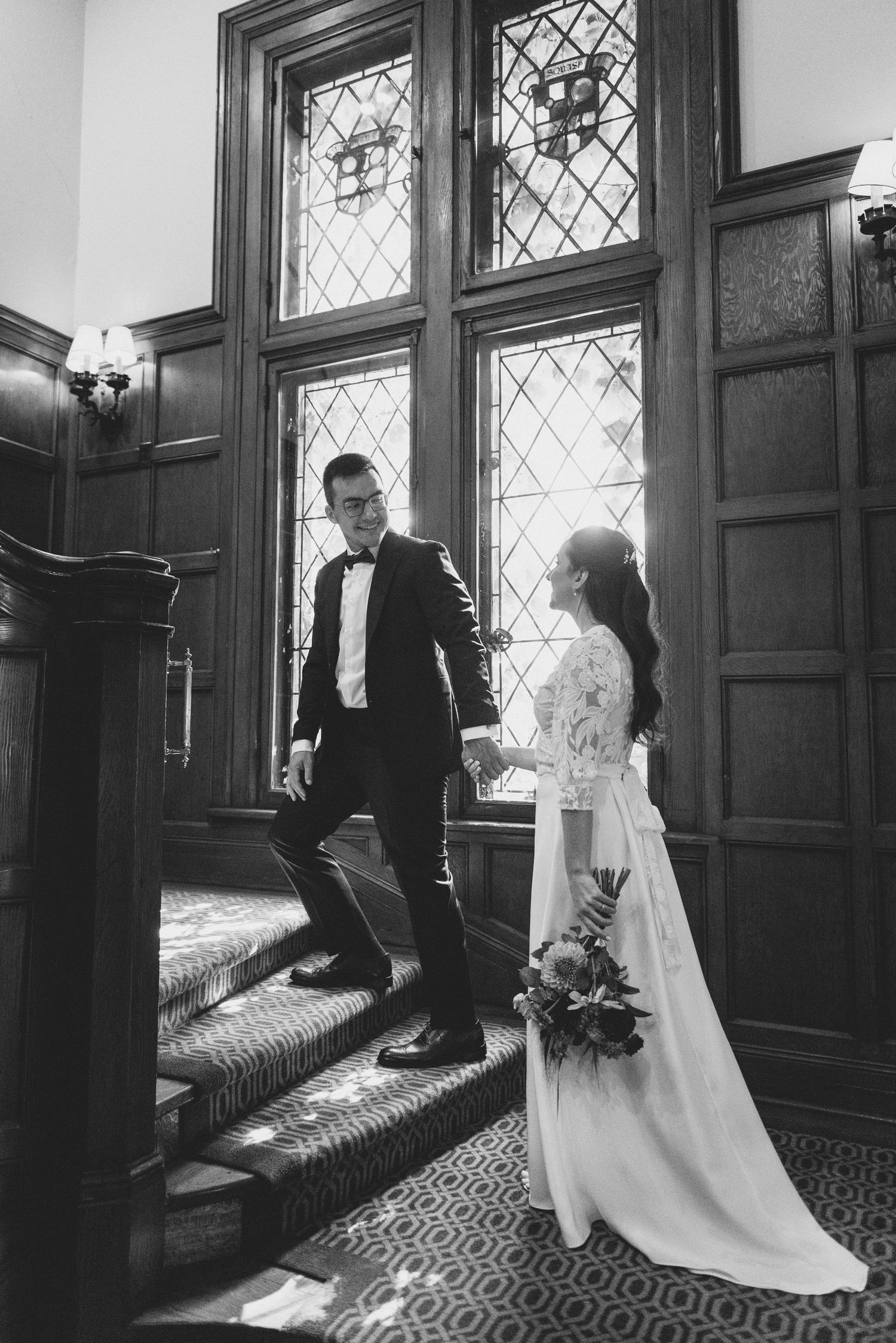Black and white wedding photos showing couple in elegant interior with leaded glass windows and patterned carpet.