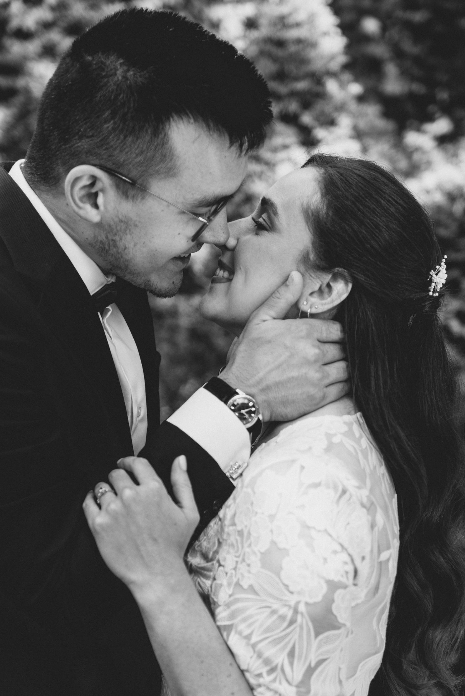 A romantic black and white photo series showing a couple sharing intimate kisses in their wedding attire.