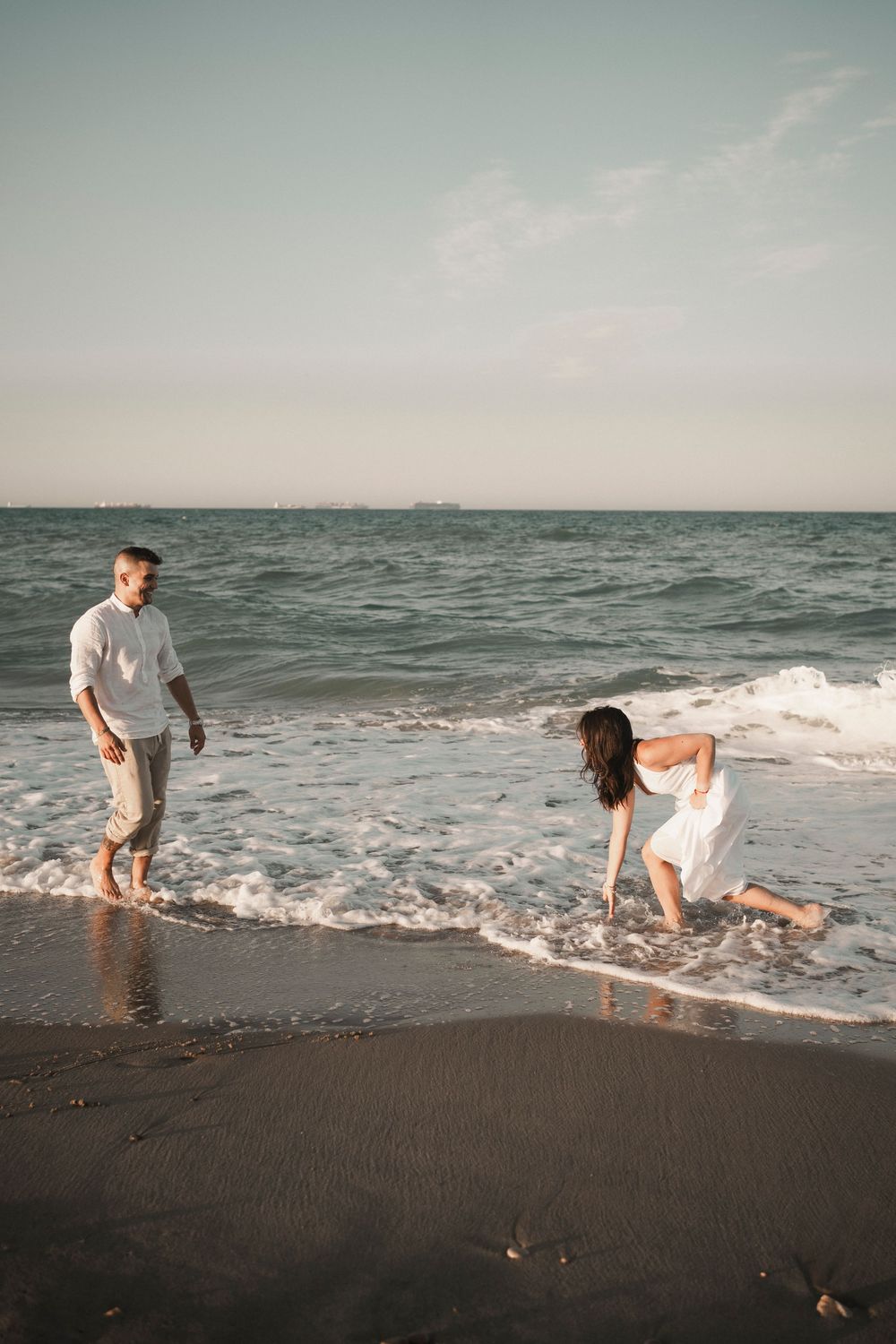 Intimate look between an engaged couple during a romantic sunset beach session in Venice.