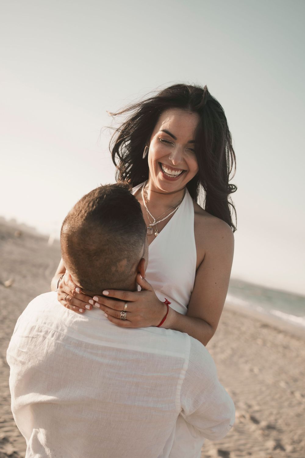 Candid portrait of a wind-swept couple smiling during their Italian riviera pre-wedding.
