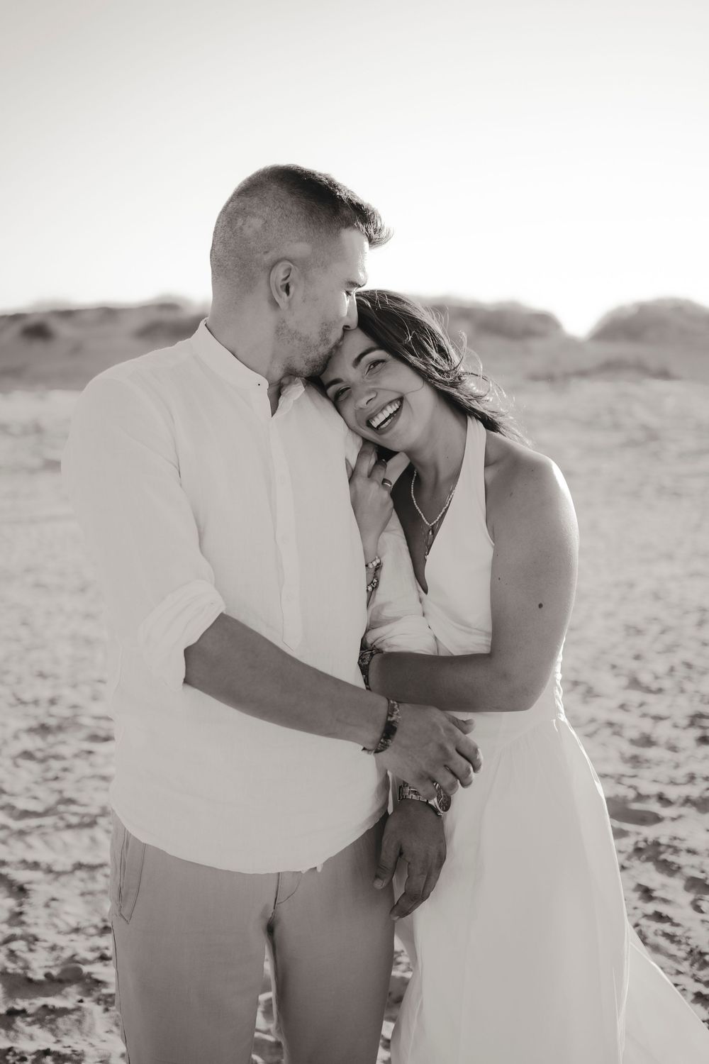 Atmospheric couple photography on an empty beach during the blue hour after sunset.