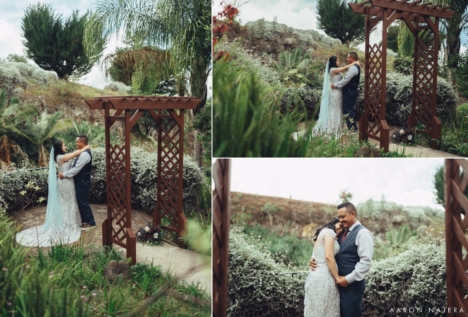 Wedding couple poses beneath rustic wooden pergola in garden setting during outdoor ceremony.