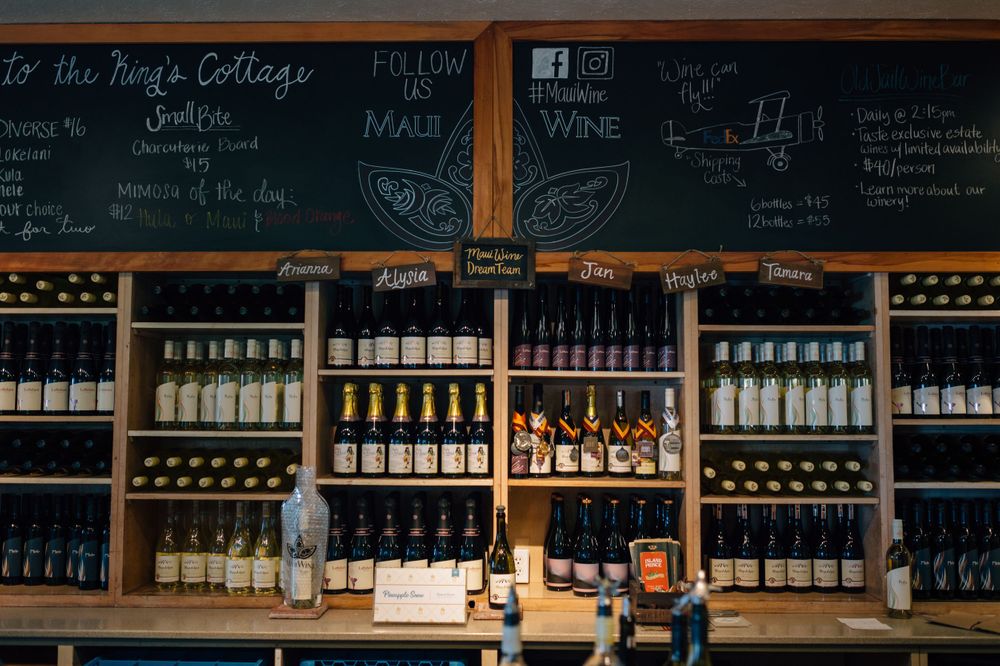 Panoramic view of wine bar interior showing long counter and wall-mounted wine bottle displays.