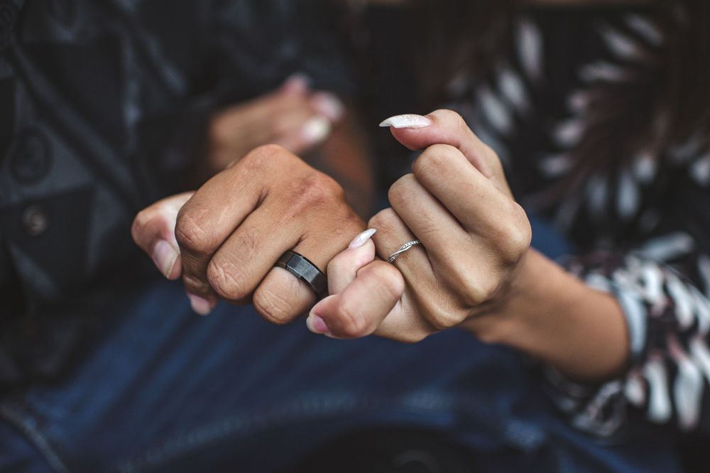 Close-up of intertwined hands showing intimacy and connection.
