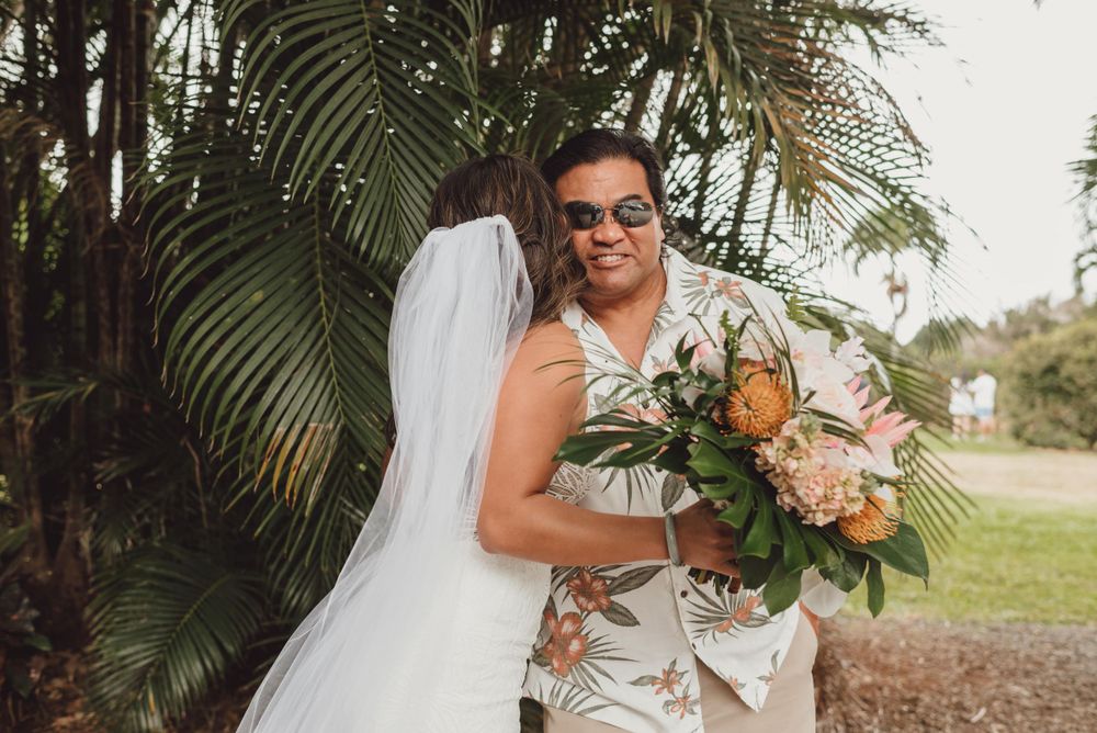 Elegant outdoor wedding ceremony setup with tropical flowers and palm trees creating a natural backdrop.