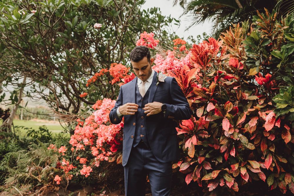 Beautiful tropical garden with vibrant coral-colored flowers and lush greenery creates a romantic wedding backdrop.